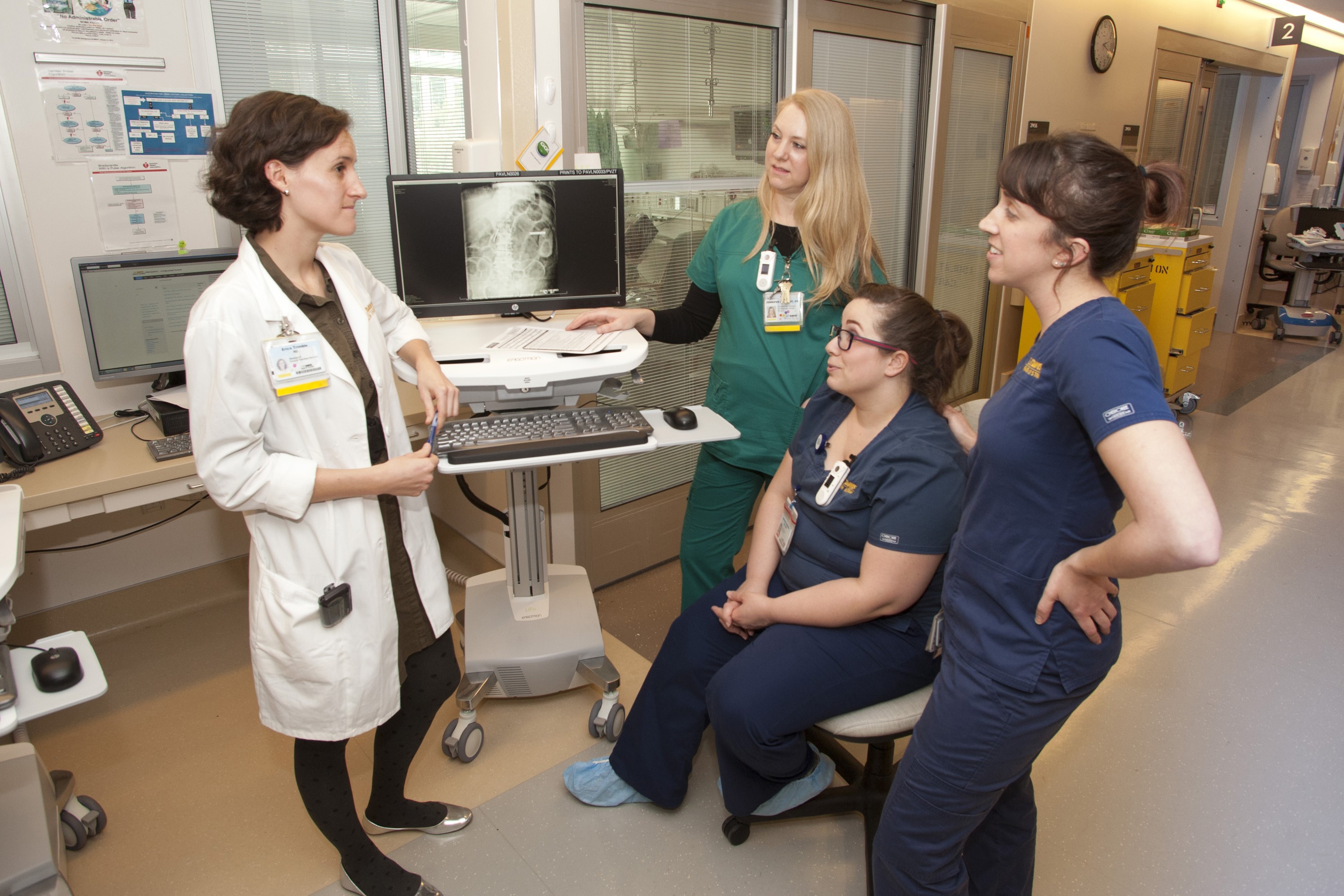 Four Dietitians discussing in a hospital hallway